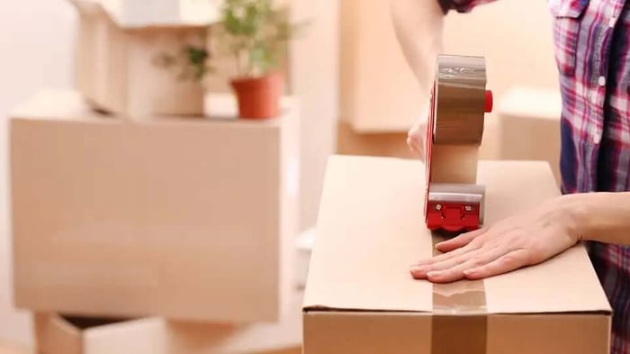 a person packing a moving box for storage