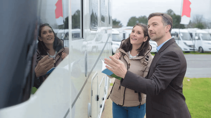 a woman being shown an RV by a salesman
