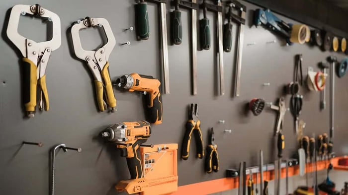 a workspace and tool board covered in drills and other tools