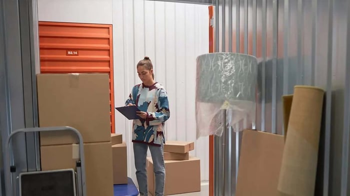 a business owner doing inventory in their storage unit surrounded by boxes