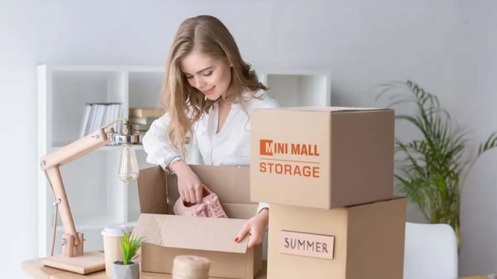 a woman using Mini Mall STorage moving boxes for seasonal storage