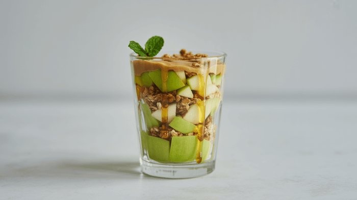 Green apple slices with almond butter and cinnamon in a glass
