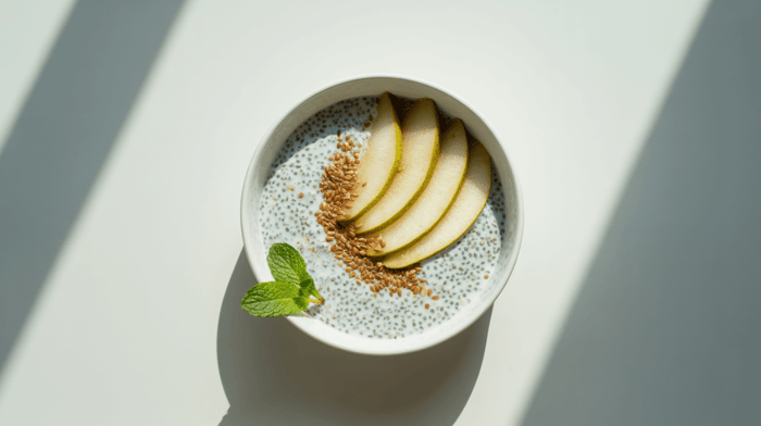 Coconut-chia pudding topped with sliced pear and flax seeds