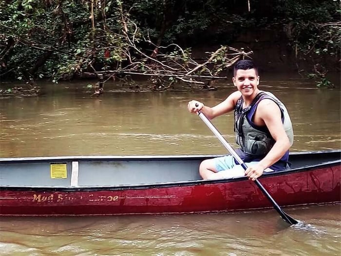 Teenage Isaac all smiles in his canoe
