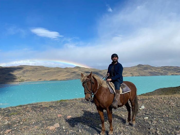 A rainbow on display on a ride next to the blue lake