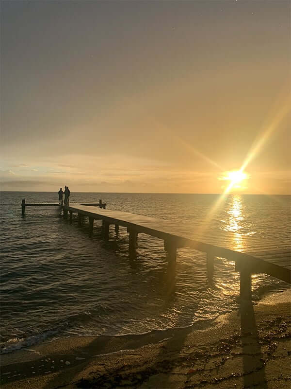 Laura’s view of a pier and a Belizean sunset