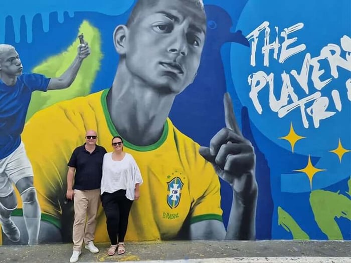 Martin and Sarah in front of a Richarlison-themed mural in Sao Paolo