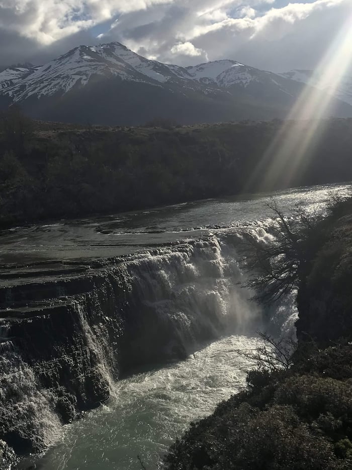 Sun rays illuminating a river through the moody Patagonian skies