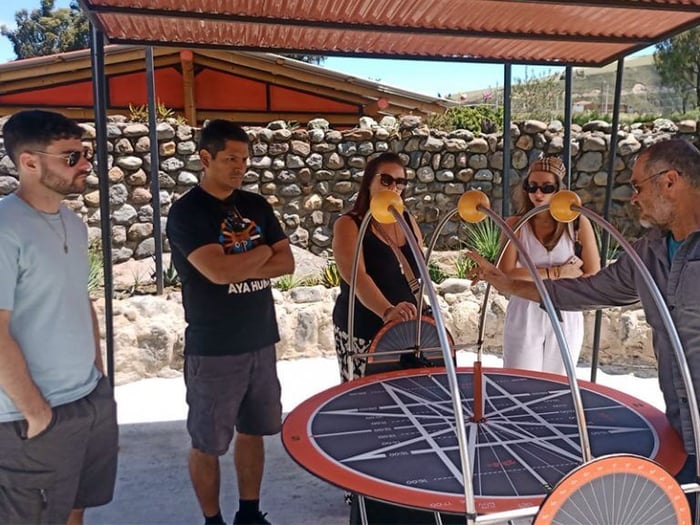 The group take in a tour guide’s knowledge of the equator