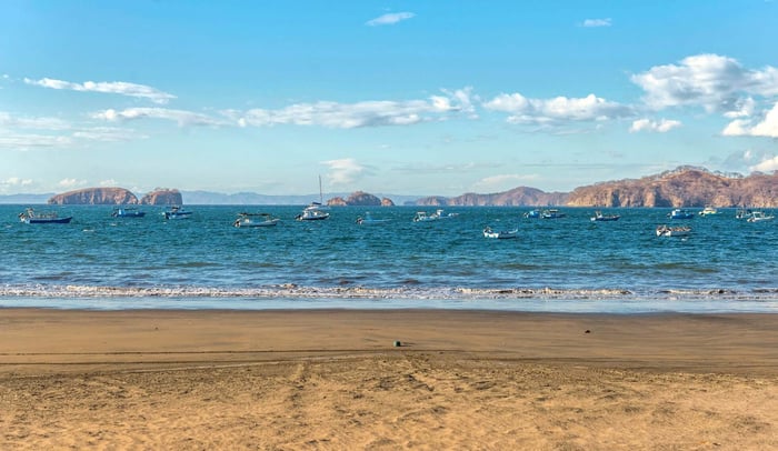 Fishing boats on the ocean with amazing landscape. Playa Hermosa, Guanacaste - Costa Rica. Central America.