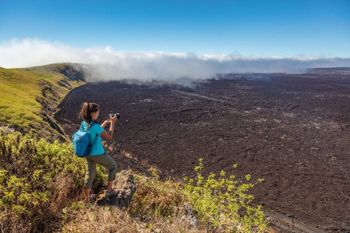 Galapagos tourist hiking on volcano Sierra Negra on Isabela Island