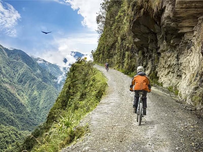 Neighbours Peru and Bolivia share similar history and geography and are home to some of the best off-the-beaten-track experiences in South America. So if you fancy immersing yourself in their incredible landscapes away from the hustle and bustle of the main thoroughfares, then off-road activities are one of the best ways to do so whilst having maximum fun as you go!   Peru  Sacred Valley & Machu Picchu The Sacred Valley is a magical place for both Inca ancestry and today’s adventurer on four (or two) wheels. Quad biking tours – known locally as ATVs – offer great views of the majestic Andes with stop-offs at local attractions such as the salt mines in Ollantaytambo.  Archaeological Incan gems await via the multi-day trek options to Machu Picchu, all of which take you through breathtakingly scenic jungle terrain where you can witness alpacas and condors, indigenous people, plus glacial lakes and ice-capped mountain peaks on certain hiking routes.    ATV rider in Sacred Valley, Peru   Ica – Huacachina Huacachina is located in the middle of the Ica desert, just ten minutes from the city, and is the only desert oasis in South America. You will be able to appreciate an incredibly dark green lagoon, contrasting against the imposing dunes. Here, you can enjoy tubing, sandboarding (sunset is recommended), and ATVs.    Desert oasis at sunset Ica – Paracas National Reserve Considered one of the best natural attractions in Ica and the only protected area in Peru with a marine ecosystem, this national treasure provides vast wilderness and paragliding options for those wishing to take in its beauty from a bird’s eye view.  Penguins at Paracas National Reserve Paragliders in Paracas Part of the reserve is the Ballestas Islands, Peru’s (smaller) version of the Galapagos. Another layer of adventurous seclusion is thrown into your trip by the fact you can only get there by boat, and on the way in you will sail past El Candelabro, a wonder of an ancient geoglyph crafted into the side of a hill. The islands are home to thousands of sea lions, Humboldt penguins, flamingos, and various migratory birds.   Paragliding at Paracas National Reserve    Trujillo & Chiclayo The main cities in lesser visited northern Peru – forming part of the Moche Route – are Trujillo and Chiclayo. These places house pre-Colombian archaeological sites and ruins, including the vast Adobe Palace complex of Chan Chan, the Huaca del Luna and Huaca del Sol, as well as the Tucume Valley with its impressive array of pyramids and tombs.    Trujillo & Chiclayo Sunset At the Pacific coastline of Trujillo you’ll leave all roads behind you with beaches that boast some of the world’s best surf conditions, in addition to great sandboarding opportunities!    Bolivia  Uyuni Salt Flats Located in southwest Bolivia, Salar de Uyuni lays horizontal for as far as the eye can see near the peak of Andes at an elevation of 11,995ft above sea level. One of the most mesmerising visual places in Latin America, these vast salt deposits are the largest in the world, spanning more than 4,000 square miles.  Take a 4x4 drive over the Uyuni Salt Flats of Bolivia   Hired 4x4s will take you across cacti-covered islands, dormant volcanoes in search of vibrant flamingos and other wildlife. In the wetter parts of the year, you will likely be treated to large bodies of standing water that act like mirrors to the sky – the perfect place for your off-road trip.       ‘Death Road’, Yungas If you’re feeling super off-road brave, then the so-called Death Road might be the two-wheeled challenge for you! Climbing to 15,260ft above sea level at La Cumbre Pass before heading to a continuous downward stretch toward the Amazon rainforest, this incredible ride is made daily by thrill-seekers looking to get the most amazing views of the area. That said, if you do take a peer off the side of the road, you’ll be looking down at a 2,000ft drop into the surrounding forest… so ride carefully!     Condor soars over Death road mountain bikers