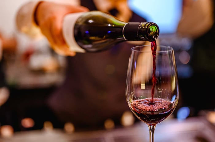 A glass of red wine being poured from the bottle
