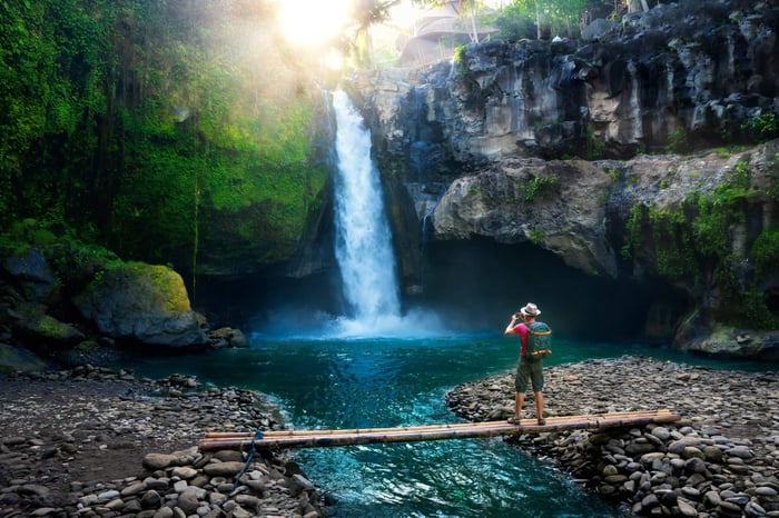 A travel photographer takes a moment to enjoy one of the waterfalls in Latin America