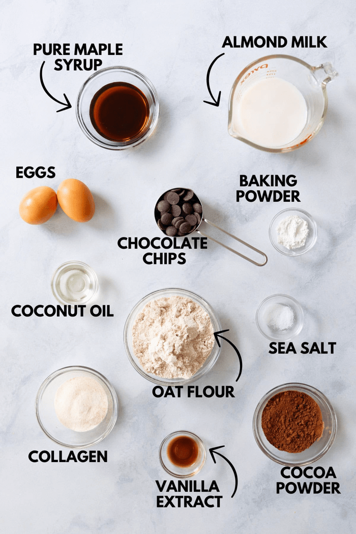 An image with ingredients for Healthy Chocolate Donuts laying flat upon a marbled white surface.