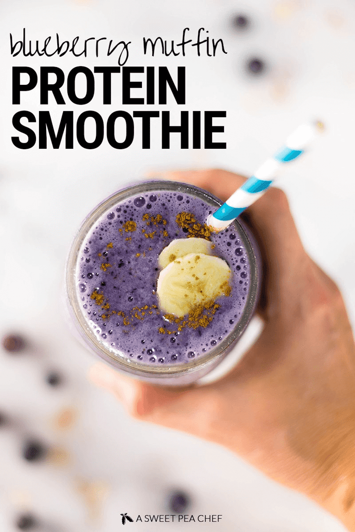 A photo showing a hand holding a finished version of blueberry muffin protein smoothie.