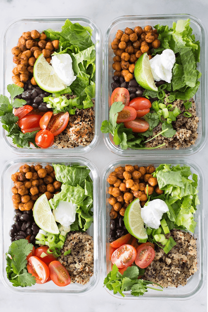 A photo of 4 meal prep containers all full of Chipotle Chickpea Taco Bowl Meal Prep.