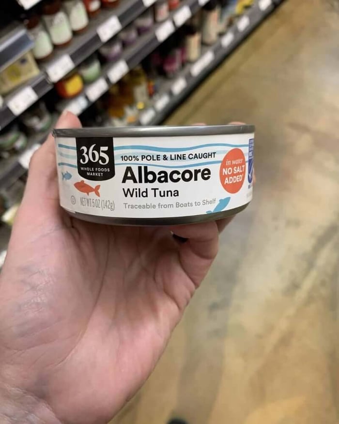 Hand holding a tuna can labeled 365 Whole Foods Tuna.