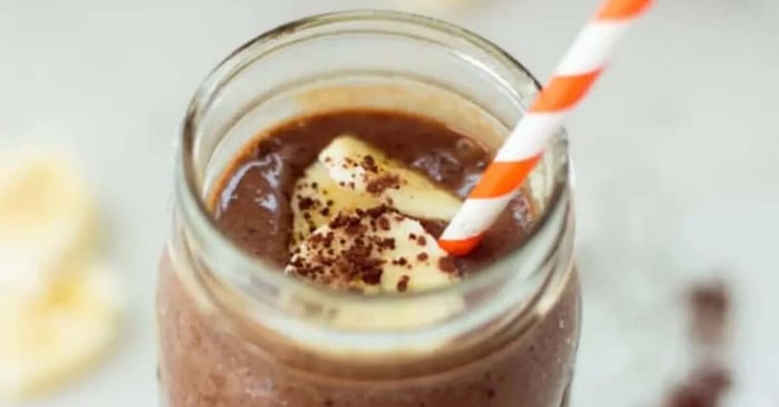 A finished version of Chocolate and Coffee smoothie with a straw in it.