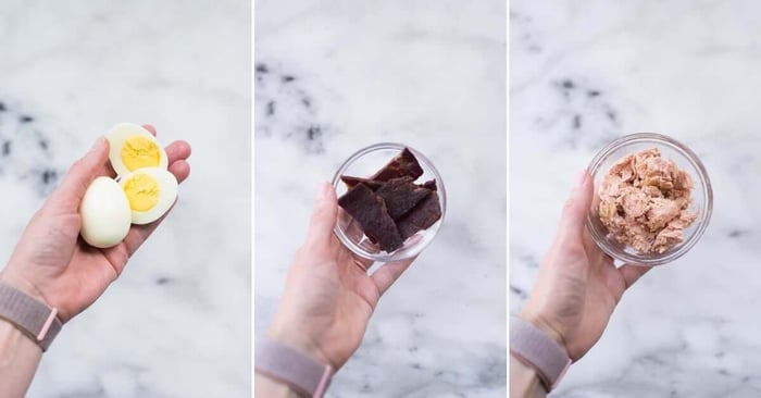 A photo of a hand holding hard boiled eggs, tuna, andbeef jerky for the featured image of High Protein Snacks.