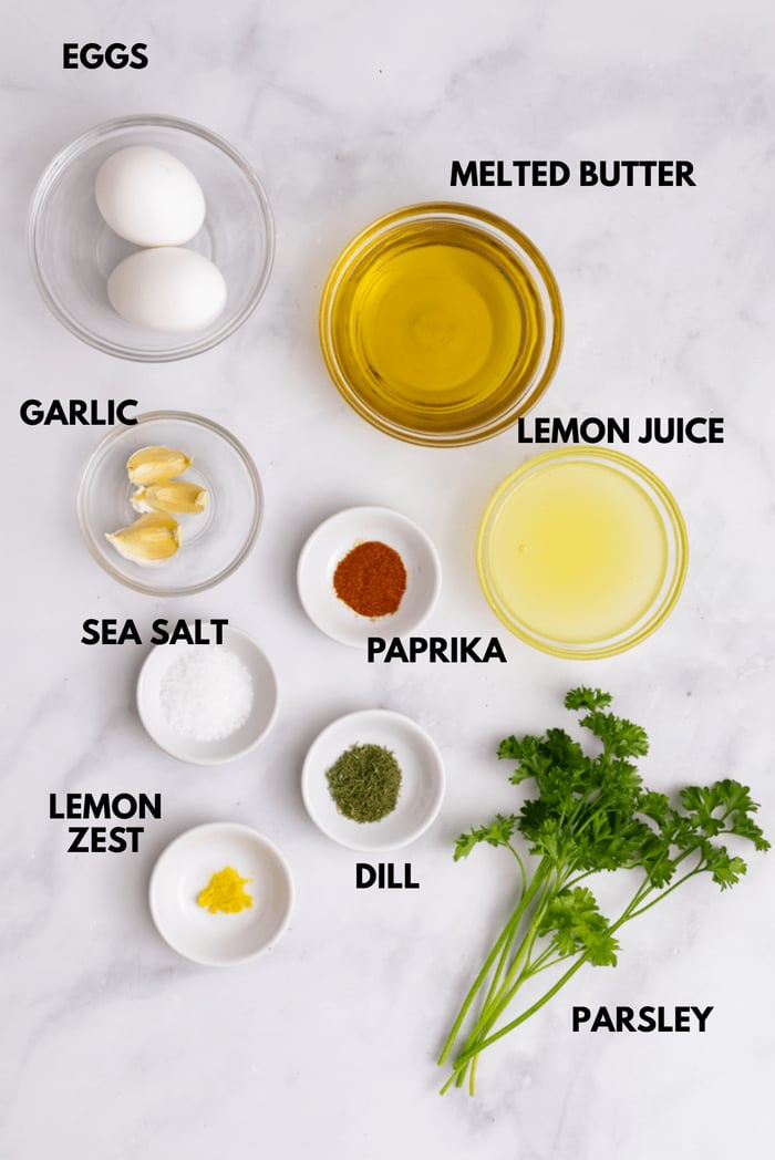 An image of ingredients for healthy crab cakes laying flat against a white marble surface.