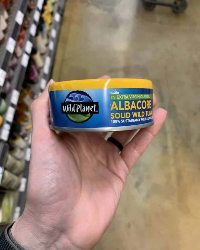 Hand holding a tuna can labeled Wild Planet Tuna.