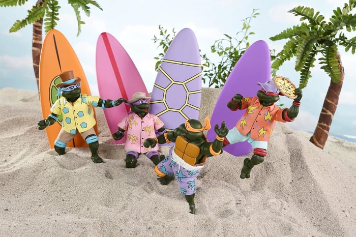 NECA’s Teenage Mutant Ninja Turtles Sewer Surfing 4-Pack displayed in packaging, featuring all four turtles with vibrant surfboards and beach-themed accessories.