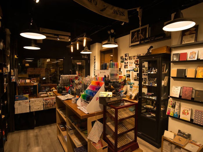 A large wall of multi-coloured back-to-school stationary in a dimly lit room.