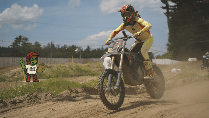 A motocross rider demonstrating the modern attack position — chest forward, elbows up, hips driving the bike — the body posture that prevents arm pump