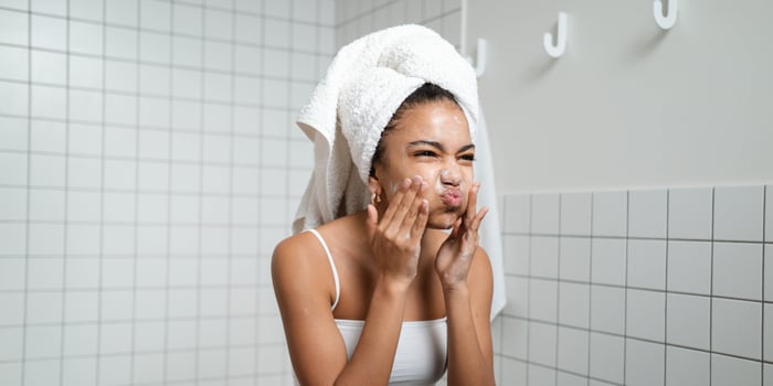 Young child washing face with childrens face washers while learning the difference between a childrens face cleanser and the best face wash for kids