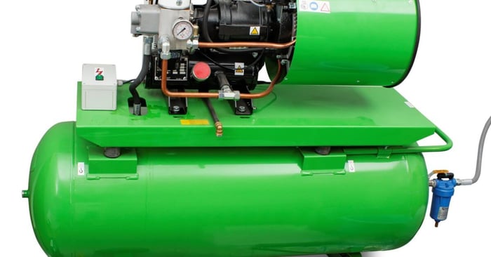 Large green industrial air compressor with a horizontal tank, motor, pressure gauge, piping, filter, and wheels.