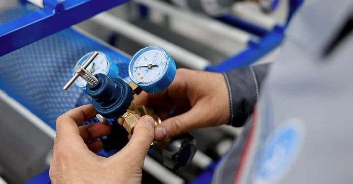 A yellow portable air compressor with a horizontal tank, black motor and pump assembly, pressure gauges, and wheels.