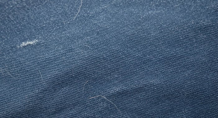 Close-up of worn denim fabric highlighting stitching and texture from the most durable clothing brands known for long-lasting craftsmanship.