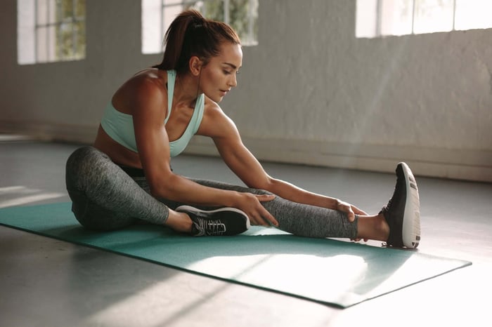 Woman stretching while wearing female yoga pants designed for flexibility, comfort, and performance