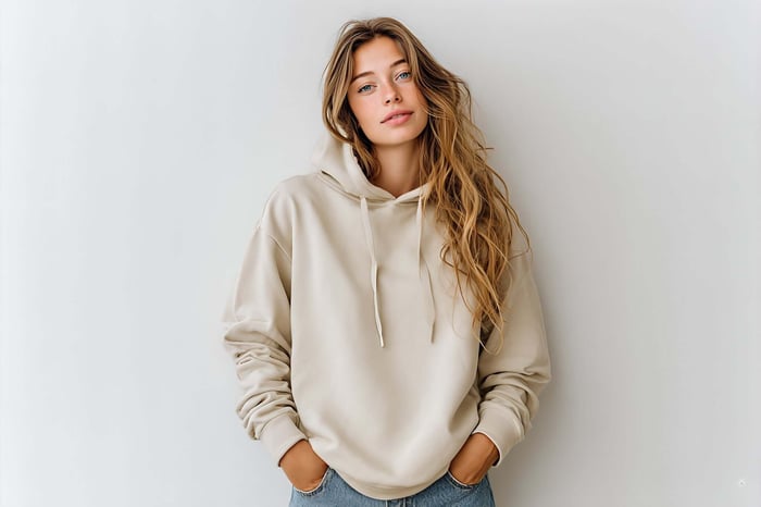 Model wearing an oversized neutral hoodie that embodies minimal streetwear style with clean lines, relaxed fit, and modern urban fashion aesthetics.