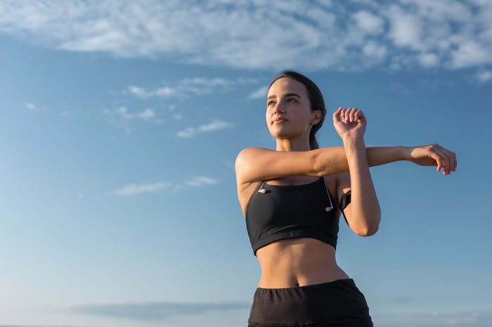 Woman stretching in comfortable PFAS-free yoga pants before a workout, demonstrating flexibility, freedom of movement, and minimalist activewear.