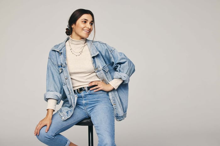 Woman wearing a denim jacket with yoga pants showing what to wear with yoga pants for a casual everyday outfit