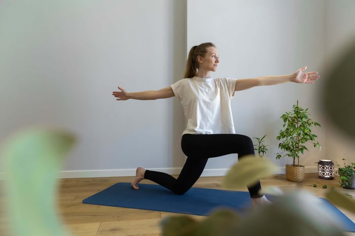 Woman wearing an oversized tee with yoga pants showing what to wear with yoga pants for a relaxed everyday outfit