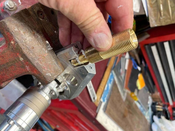 Brass fitting being threaded back into the brush assembly