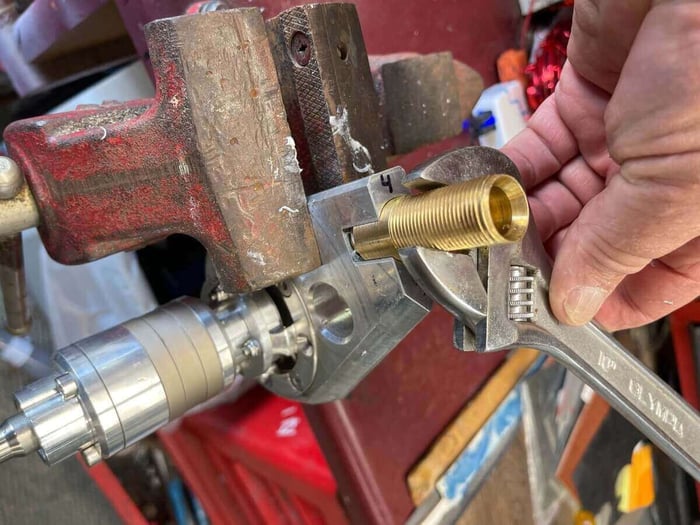 Hand-tightening the brass fitting with a wrench to just past snug