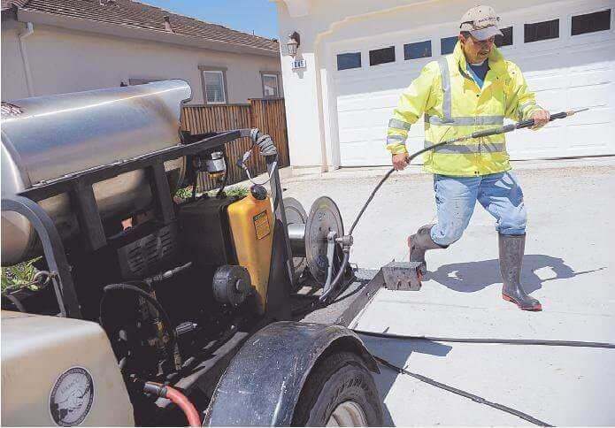 Carlos Gonzalez pressure washing on a commercial job site