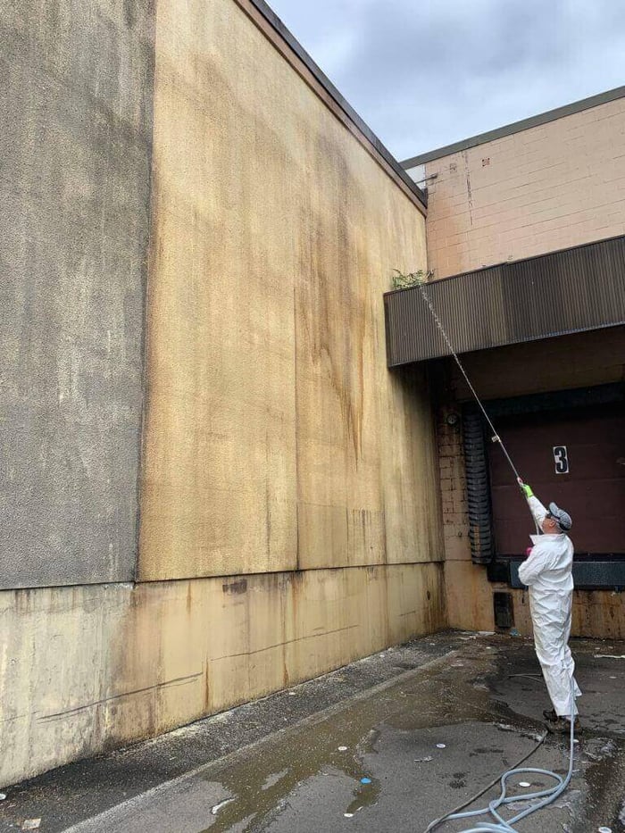 Contractor performing exterior cleaning on commercial building after J.Racenstein training