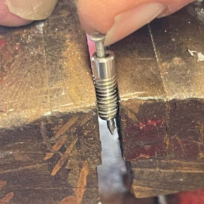 Clear nozzle orifice after debris removal, viewed against light