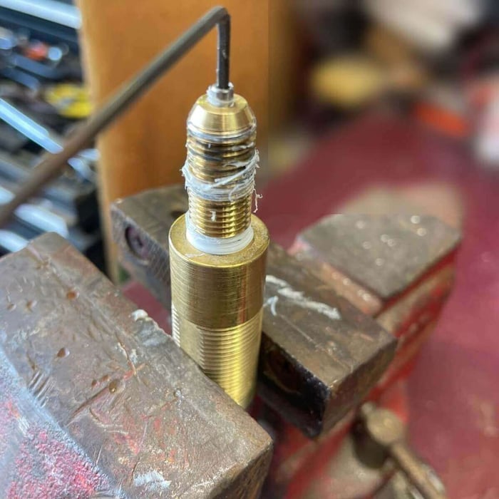 Nozzle tip being hand-threaded back into the water inlet body