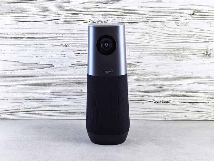 A sleek smart speaker with an integrated camera against a wooden backdrop, perfect for modern tech setups.