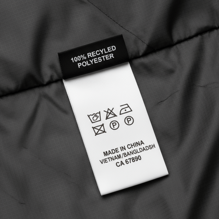 Technical outerwear sample on a mannequin with taped seams and storm flap