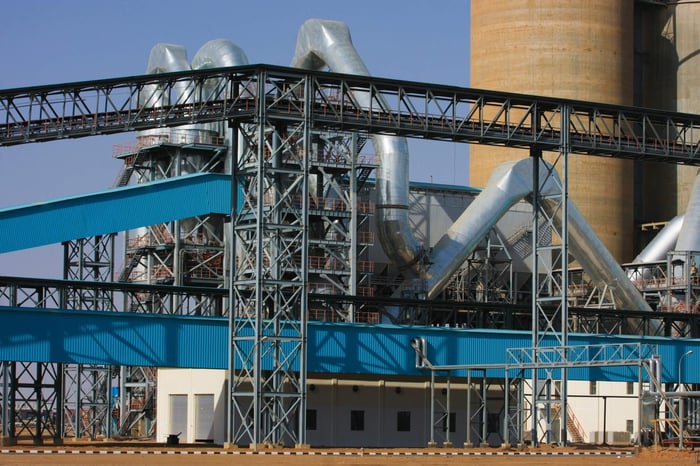 A detailed view of a large industrial factory facility with steel structures and towering pipes.