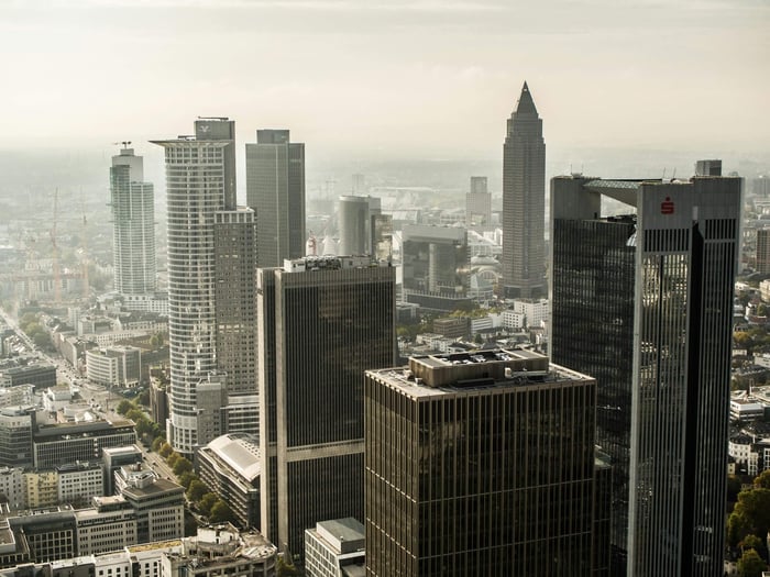 Aerial view of Frankfurt's skyscraper-filled skyline under a hazy sky.