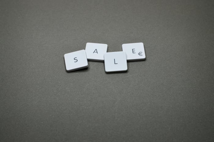 Close-up of tiles spelling 'SALE' showcasing a minimalist design theme.