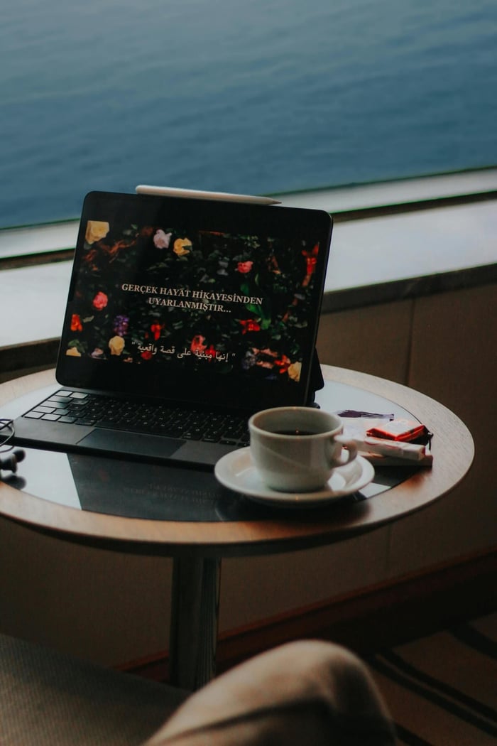 A warm café scene featuring a tablet and coffee cup on a window-side table.